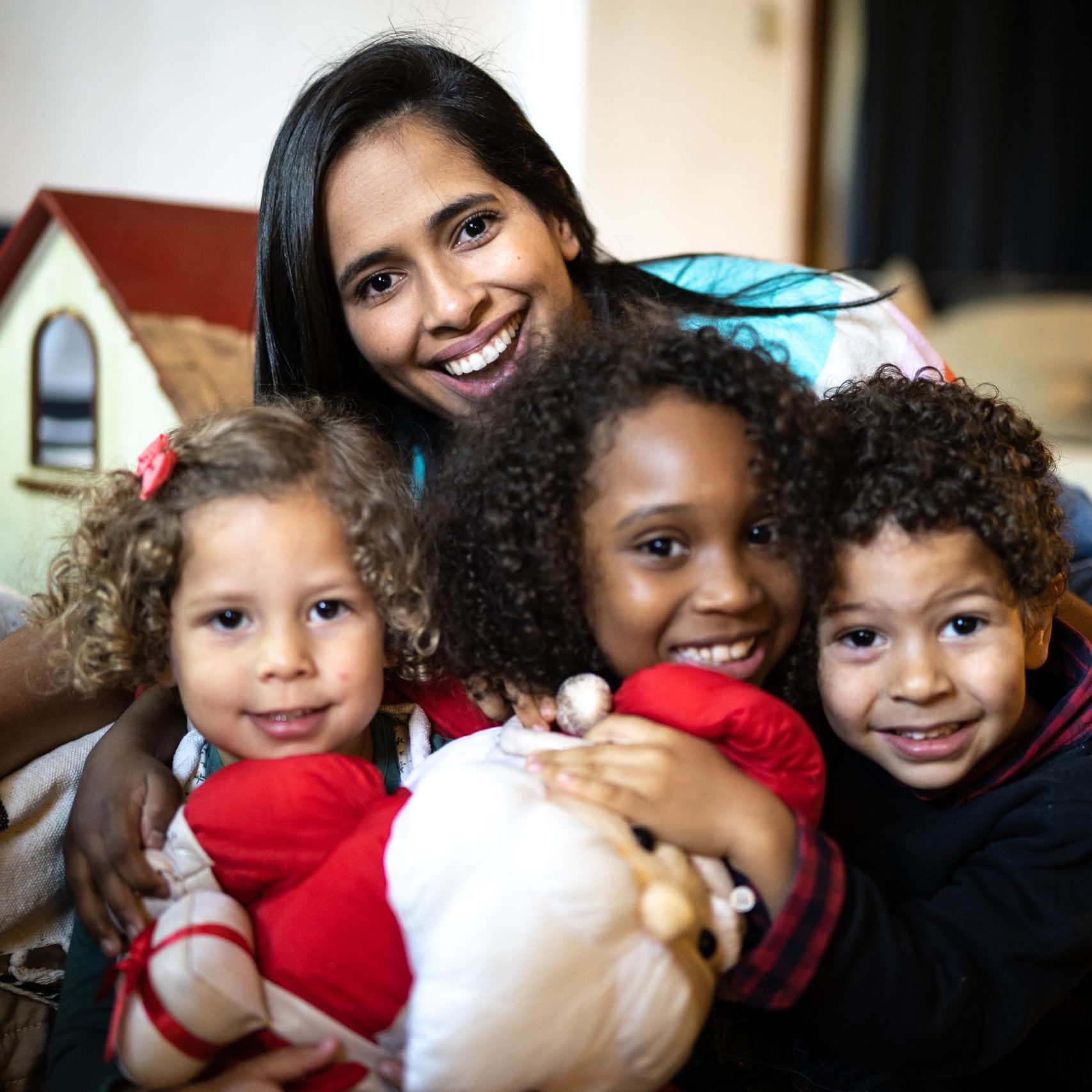 Portrait of a mother and children with a Santa Claus doll at home